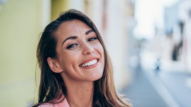 Frau lächelt mit Grübchen.
