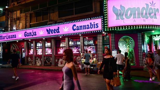 Thailändisches Cannabisgeschäft bei Nacht mit grell pinker Neonbeleuchtung