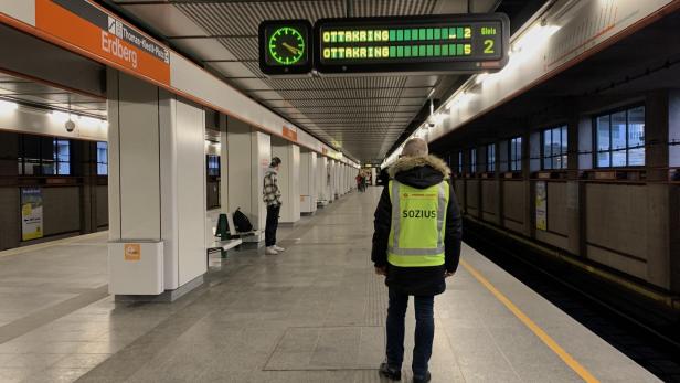 ein Mann in gelber Warnweste steht mit dem Rücken zur Kamera auf einem U-Bahnbahnsteig in Wien