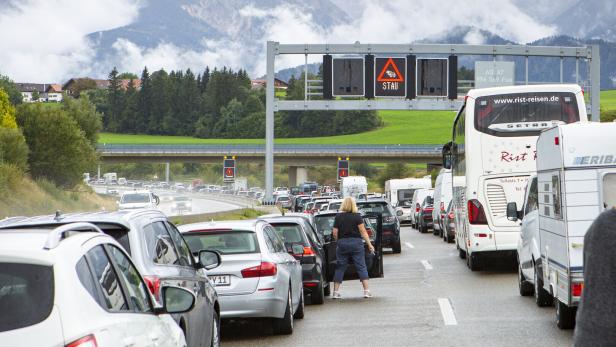 Stau auf der Autobahn vor einer Bergkulisse.