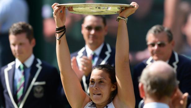 epa03778017 Marion Bartoli of France celebrates with the trophy after her victory over Sabine Lisicki of Germany in the women&#039;s final for the Wimbledon Championships at the All England Lawn Tennis Club, in London, Britain, 06 July 2013. EPA/ANDY RAIN