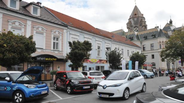 Mehrere Elektroautos stehen vor historischen Gebäuden in Horn, Österreich.
