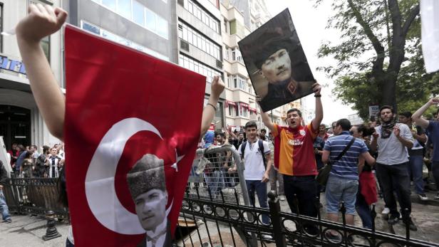epa03727831 People hold Turkish flags and a picture of Ataturk, founder of modern Turkey, as they gather, in Istanbul, Turkey, 02 June 2013. Turkish police have arrested 939 people in more than 48 cities across the nation during two days of violent protests, Interior Minister Muammer Guler said. Turkey&#039;s largest city and epicentre of the protests, Istanbul, was mostly calm 02 June morning, as light rain fell and residents assessed the damage. EPA/SEDAT SUNA