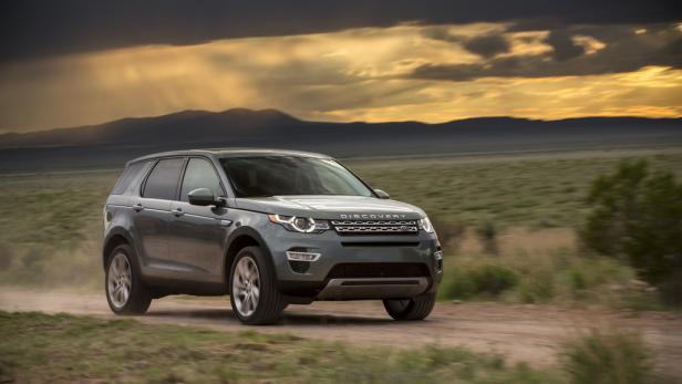 Ein grauer Land Rover Discovery fährt auf einer unbefestigten Straße in Richtung Horizont.