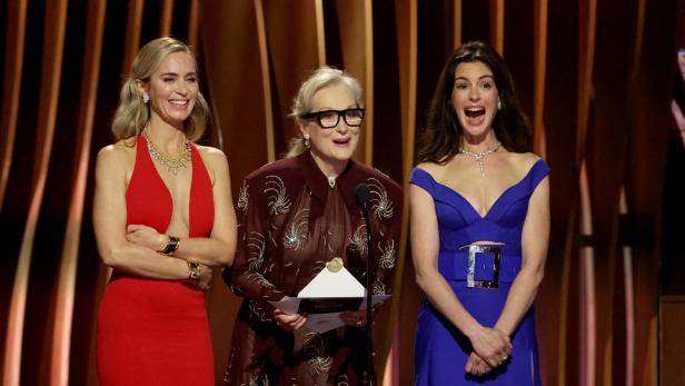 Emily Blunt, Meryl Streep und Anne Hathaway stehen auf einer Bühne.