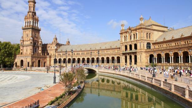 Die Plaza de España in Sevilla mit einem Kanal und vielen Besuchern.