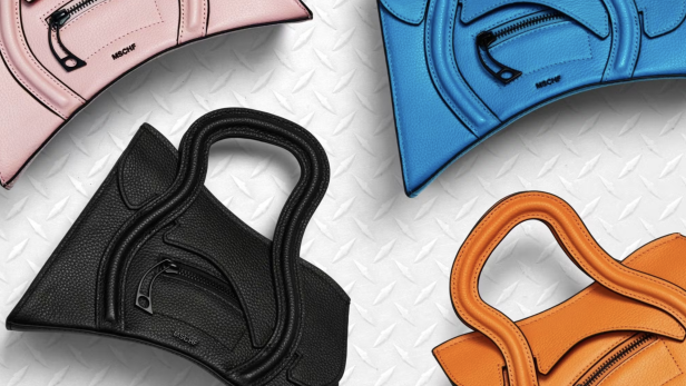 Vier MSCHF-Lederhandtaschen in Rosa, Blau, Schwarz und Orange auf einer strukturierten Oberfläche.