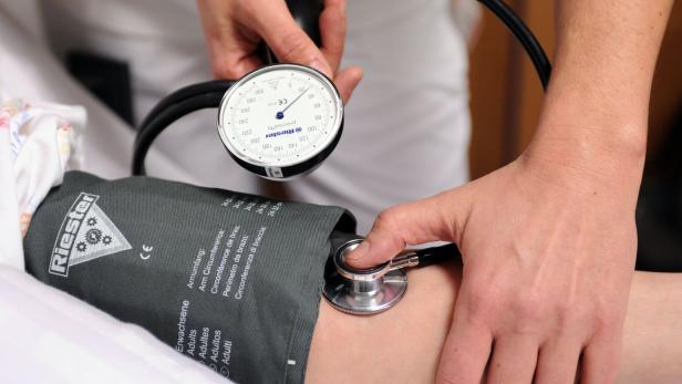 Ein Blutdruckmessgerät wird an einen Arm angelegt.