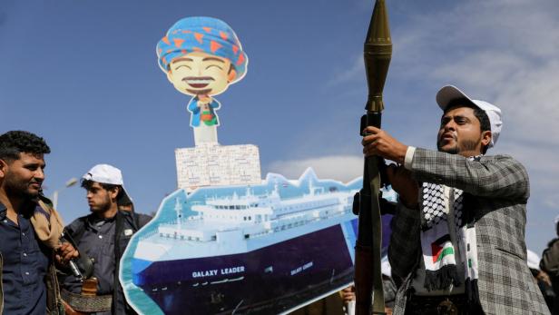 Houthis mit Waffen und Pappaufsteller eines Schiffs bei einer Parade in Sanaa