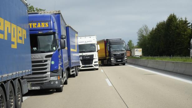Mehrere Lastwagen stehen auf einer Autobahn im Stau.