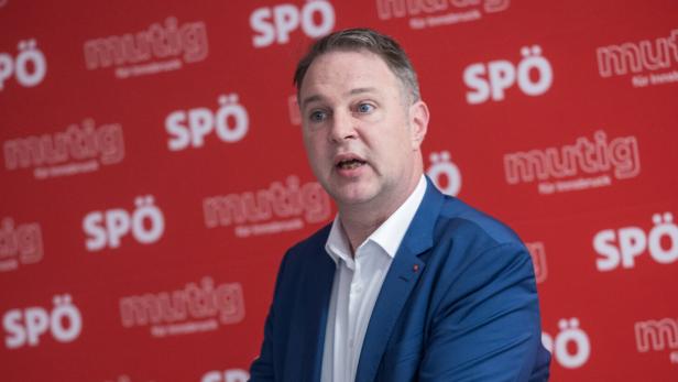 Andreas Babler redet in Innsbruck  vor einer roten Wand mit SPÖ-Schriftzug