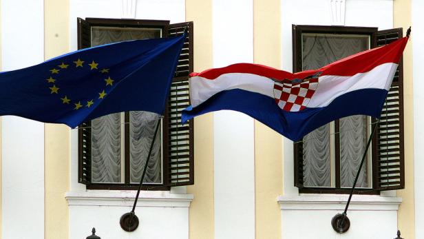 epa03757462 A Croatian national flag (R) and a European Union flag (L) fly side by side in front of the government building in Zagreb, Croatia, 24 June 2013. Following the successful ratification of its European Union Accession Treaty by the national parliaments of the 27 member states, the Republic of Croatia is set to join the European Union as the organization&#039;s 28th member on 01 July 2013. EPA/ANTONIO BAT