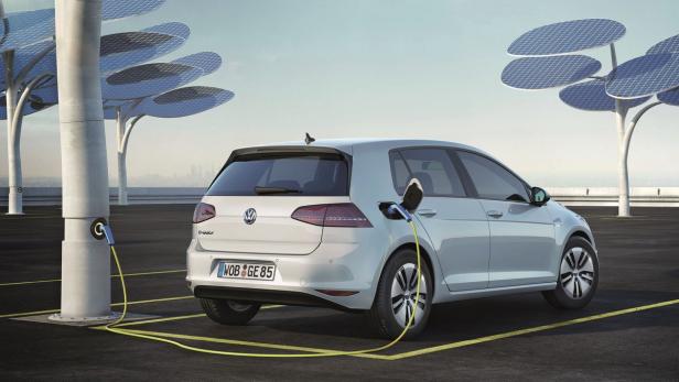 Ein silberner VW e-Golf wird an einer Ladestation mit Solarbaum-Design aufgeladen.