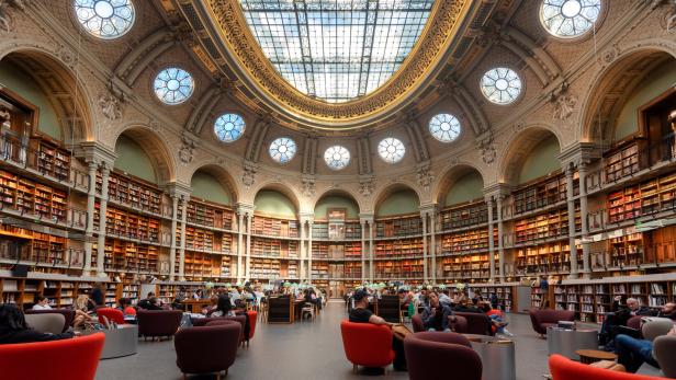 Der Lesesaal der Bibliothèque nationale de France in Paris mit Besuchern und Bücherregalen.