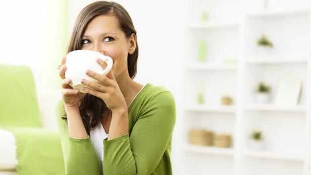 Eine Frau trinkt aus einer Teetasse.