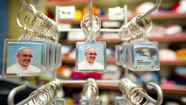 epa03779209 Key chains with portraits of Pope Francis are seen in a souvenir shop on Lampedusa Island, Italy, 07 July 2013. Pope Francis will visit Lampedusa, the Italian island half-way between Sicily and Tunisia where tens of thousands of migrants rescued at sea are taken each year, on 08 July. EPA/CIRO FUSCO