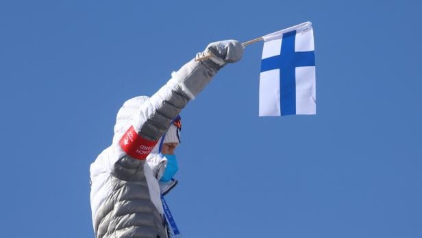 Frau weht finnische Flagge bei Sport-Event