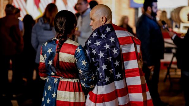 Eine Frau und ein Mann haben sich in eine amerikanische Flagge gehüllt