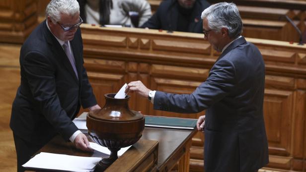 Wahl des Parlamentspräsidenten in Portugal, Politiker platzieren Stimmzettel in Urne aus Ton.