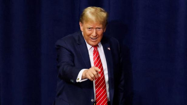 Donald Trump in roter Krawatte deutet mit dem Zeigefinger in die Kamera