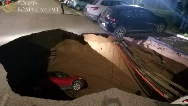 Mitten in der Nacht tat sich in Rom ein riesiges Erdloch auf und hat und zwei geparkte Autos verschlungen. 
