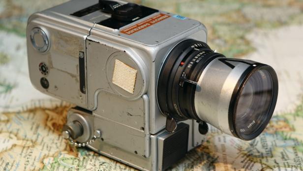 Eine alte Filmkamera der Marke Biogon steht auf einer Landkarte.