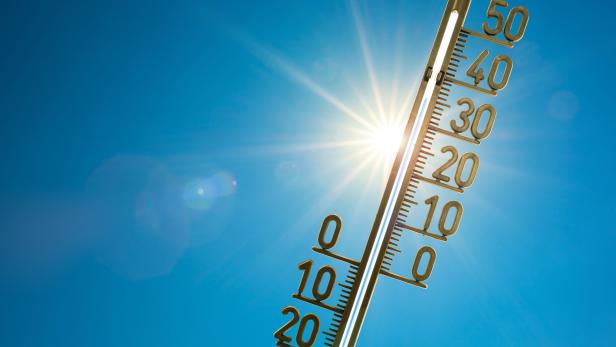 Ein Thermometer wird in den blauen Himmel gehalten, mit strahlender Sonner. Besonders zentral ist die Zahl 20