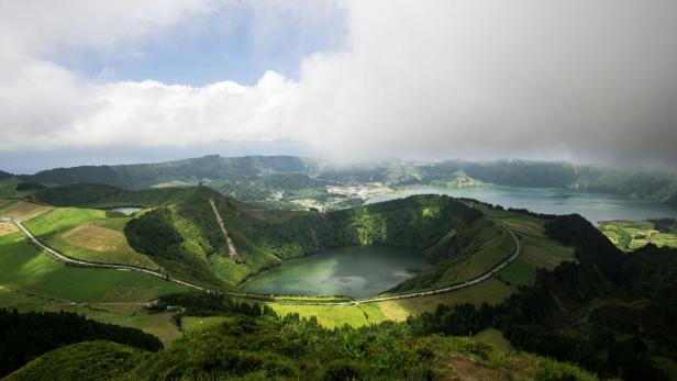 Blick auf die grüne Landschaft und einen Kratersee auf den Azoren.