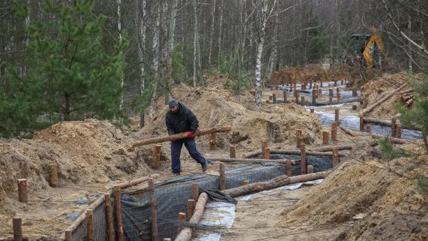 Ukrainischer Arbeiter baut Befestigungslinien mit Holzstämmen aus