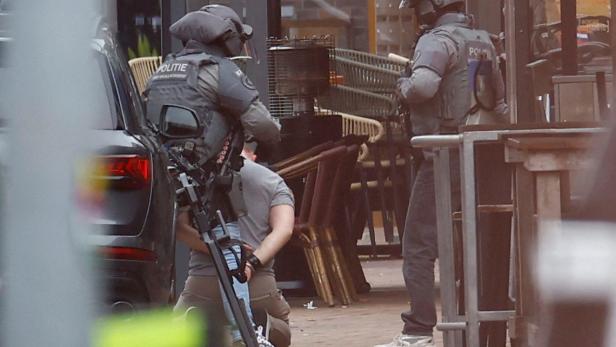 Festnahme bei Geiselnahme in Café im niederländischen Ede, Mann kniet in Handschellen vor Polizisten
