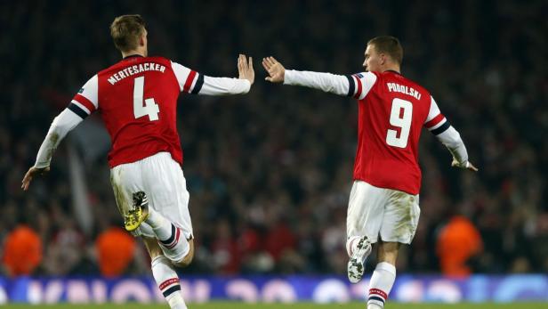 Arsenal&#039;s Lukas Podolski (R) celebrates with teammate Per Mertesacker after scoring against Bayern Munich during their Champions League soccer match at the Emirates Stadium in London February 19, 2013. REUTERS/Eddie Keogh (BRITAIN - Tags: SPORT SOCCER)