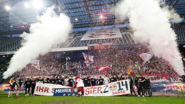 Das Fußballteam feiert mit Konfetti und Rauch seinen Meistertitel.