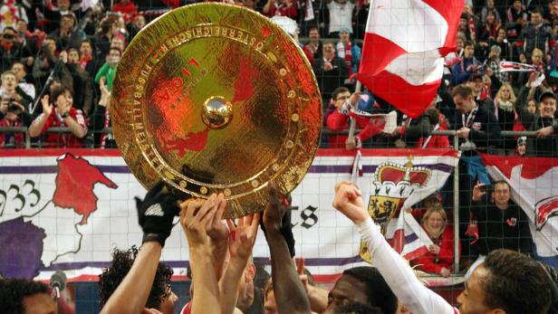 Fußballspieler halten die Meisterschale der österreichischen Bundesliga in die Höhe.