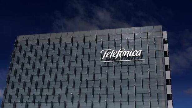 Das Telefónica-Logo an einem modernen Bürogebäude vor blauem Himmel.
