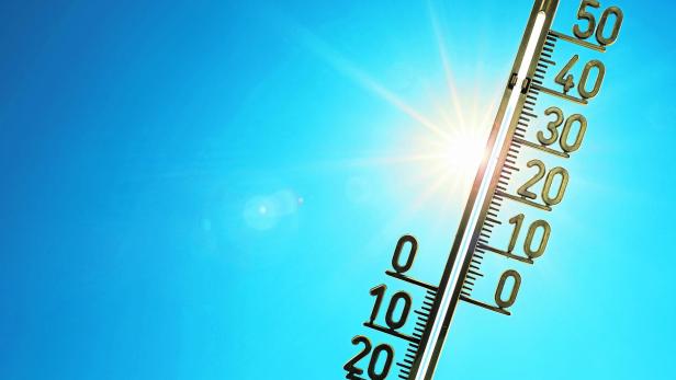 Thermometer mit hohen Temperaturen vor einem blauen Himmel mit Sonne