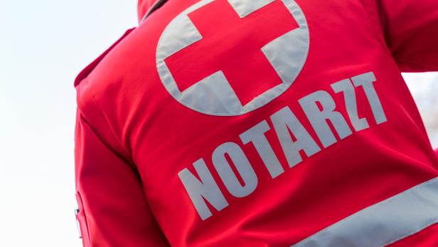 Ein Notarzt im Einsatz mit seinem Rücken zur Kamera.