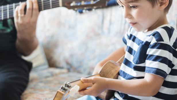 Ein Kind spielt Gitarre.