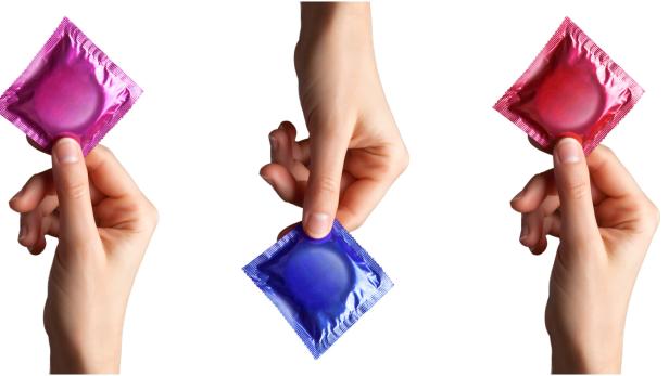Hände halten Kondome.