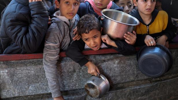 Palästinensische Kinder warten in Rafah im südlichen Gazastreifen auf Essen, das von einer Wohltätigkeitsküche gekocht wurde, 5. Februar 2024. 