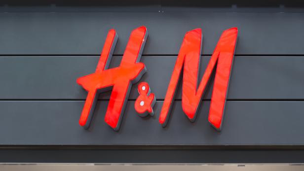 Das rote H&M-Logo an einer grauen Fassade.