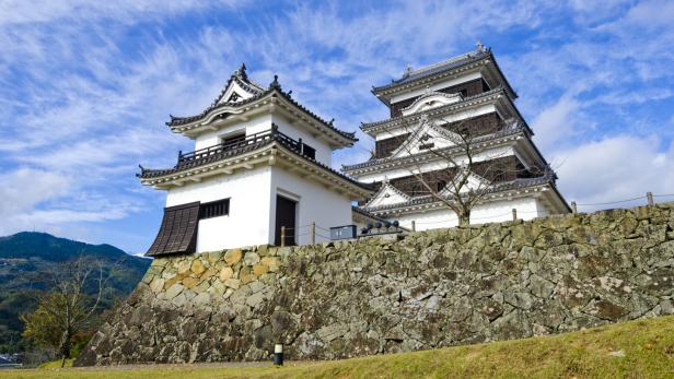 Die Burg Ozu in Japan steht auf einer steinernen Anhöhe.