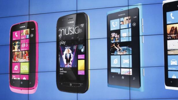 Mehrere Nokia-Smartphones mit Windows Phone-Betriebssystem werden auf einem blauen Bildschirm dargestellt.
