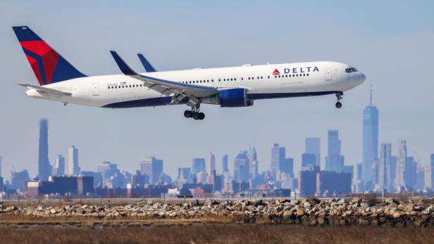 Delta-Flugzeug im Landeanflug vor der Skyline von New York.