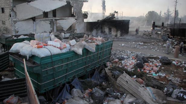 Ein LKW ist mit Hilfsgütern vor zerstörten Gebäuden beladen.