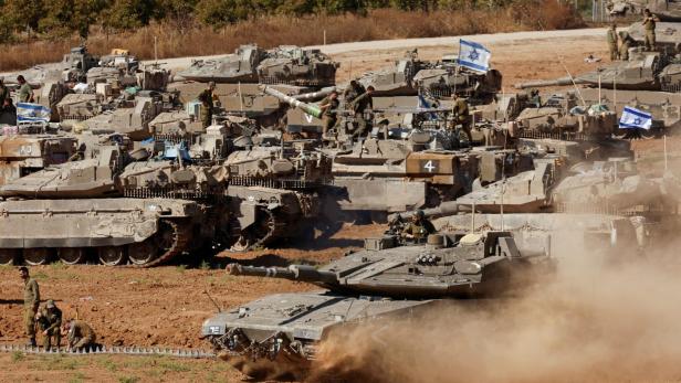 Israelische Panzer fahren auf staubigem Terrain im Süden Israels.