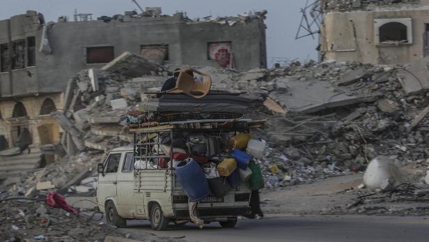 Menschen fliehen in einem überladenen Transporter aus dem zerstörten Rafah