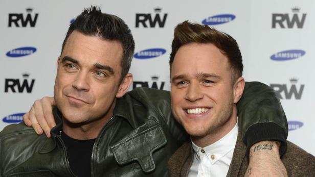 British musicians Robbie Williams (L) and Olly Murs pose for a photograph in central London November 26, 2012. Olly Murs will support Williams on his 2013 European tour, it was announced on Monday. REUTERS/Paul Hackett (BRITAIN - Tags: ENTERTAINMENT SOCIETY)