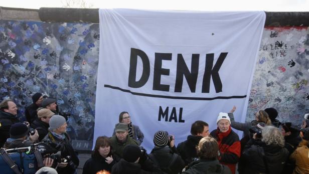 A banner which reads &quot;Think about&quot; is fixed during a protest at the open air 0.8-mile painted section of the Berlin Wall known as the &quot;East Side Gallery&quot; in Berlin March 3, 2013. Developers plan to build luxury apartments close to the East Side Gallery, which is adorned with the work of artists such as Keith Haring and Gerald Scarfe, but builders had to stop tearing down the wall on Friday due to protests. REUTERS/Fabrizio Bensch (GERMANY - Tags: POLITICS SOCIETY CIVIL UNREST BUSINESS CONSTRUCTION REAL ESTATE CITYSCAPE)