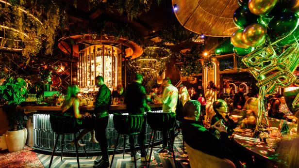 Gäste sitzen und stehen an der Bar des Restaurants Ziizuu.