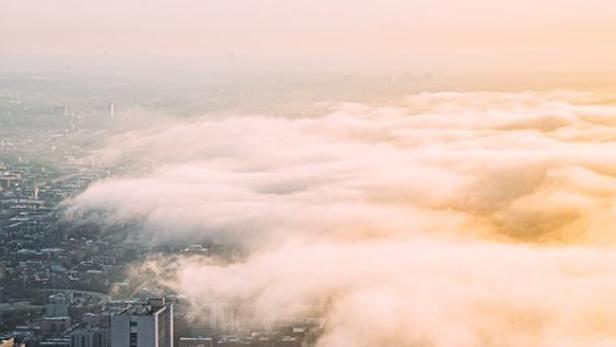 Große Wolke breitet sich über den Häusern einer Stadt aus